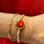 Gold beaded stretch bracelet with a raw red coral stone centered.