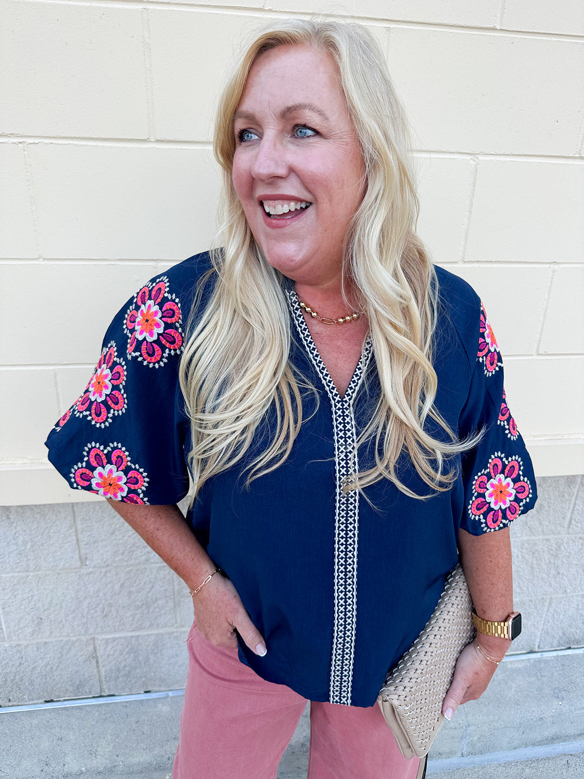 Navy puff sleeve top with ruffle neck and pink-orange floral embroidery