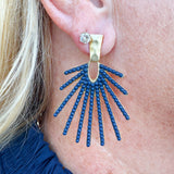 Navy statement drop earrings with a sunburst design, shown on a neutral background to highlight shine and shape