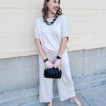 Women’s cream two-piece lounge set with dolman sleeve top and flowy wide-leg pants with pockets