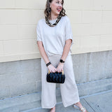 Women’s cream two-piece lounge set with dolman sleeve top and flowy wide-leg pants with pockets