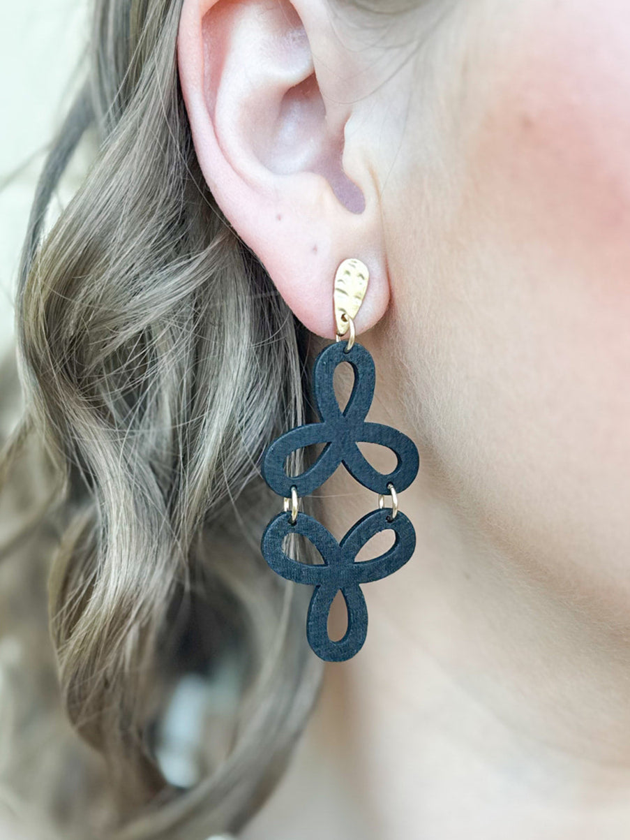 Black and gold drop earrings with two cascading open floral outlines