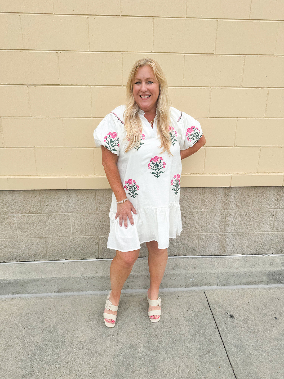 Cream mini dress with pink embroidered flowers and green stems, puff sleeves, and a ruffle hem