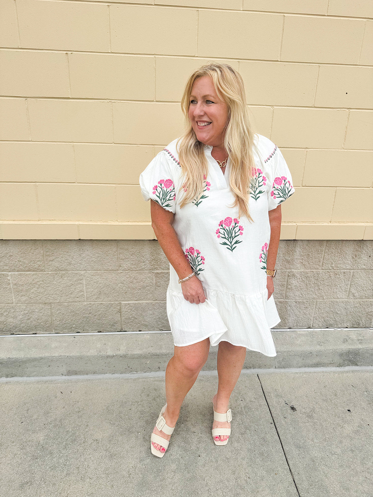 Cream mini dress with pink embroidered flowers and green stems, puff sleeves, and a ruffle hem