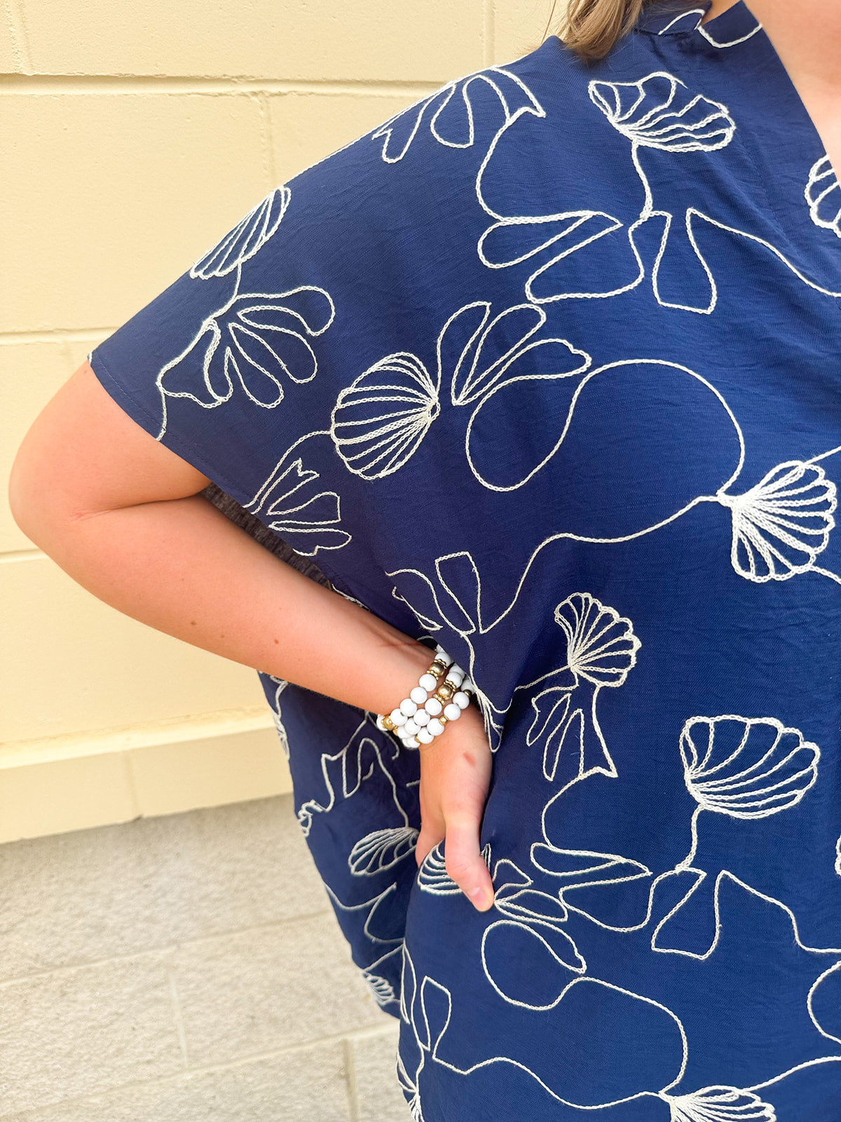 Navy oversized cotton top with cream embroidered seashells and a relaxed silhouette