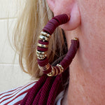Hoop earrings with garnet rubber disks and gold metal accents, styled for fall, holiday, or gameday looks.