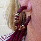 Hoop earrings with garnet rubber disks and gold metal accents, styled for fall, holiday, or gameday looks.