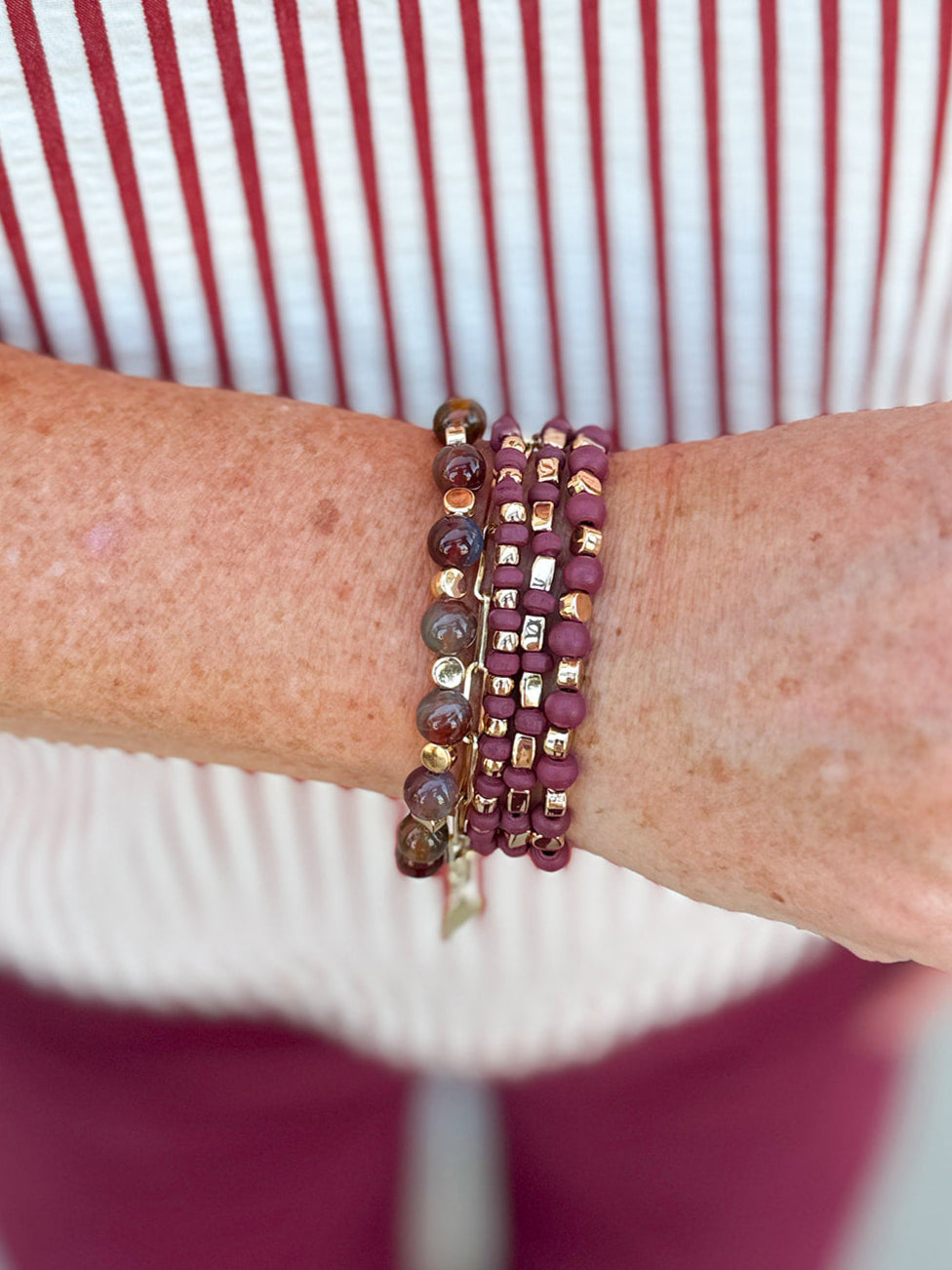 Four-stack beaded bracelet set with deep maroon, garnet, and cream beads of varying sizes