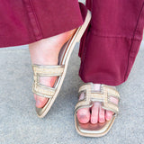 Ena Raffia H-Cutout Slides featuring a breathable raffia strap and modern H-cutout design, styled on a clean surface to showcase their chic, casual summer look and cushioned footbed