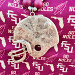 Garnet, black, and gold beaded necklace with a hammered gold football helmet pendant, styled for gameday or seasonal wear.