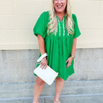 Kelly green embroidered babydoll dress with puff sleeves, tie neck, and side pockets—lightweight and perfect for warm weather