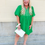 Kelly green embroidered babydoll dress with puff sleeves, tie neck, and side pockets—lightweight and perfect for warm weather