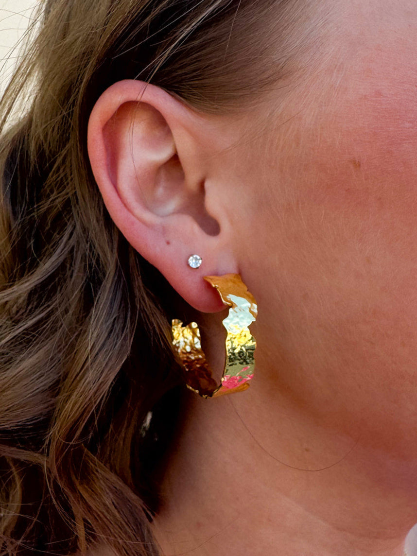 Pair of artisan-style gold-plated hoop earrings with smooth, rounded finish.