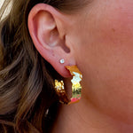 Pair of artisan-style gold-plated hoop earrings with smooth, rounded finish.