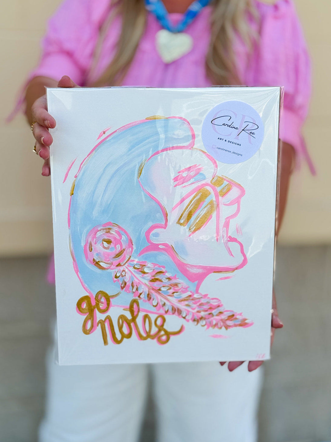 A bold and artistic 11"x14" canvas depicting a hand-painted Seminole design in bright pink, gold, and blue by Caroline Ree Designs.