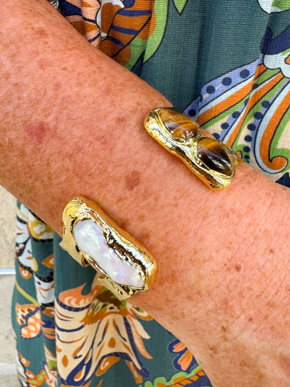 Gold cuff bracelet featuring tiger’s eye stones and a freshwater pearl accent.