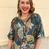 Teal abstract print top with split neckline and 3/4 banded sleeves in navy, light blue, and mocha tones.