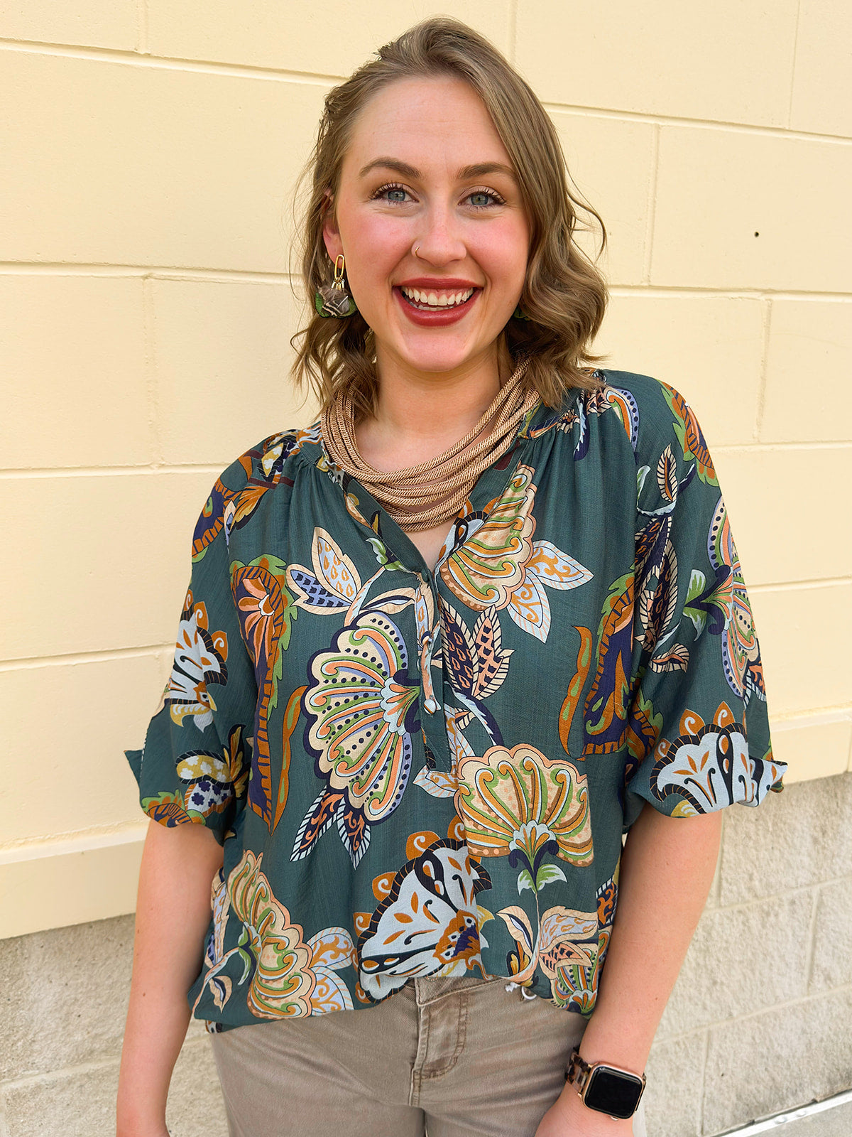 Teal abstract print top with split neckline and 3/4 banded sleeves in navy, light blue, and mocha tones.