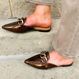 Bronze slip-on mules with glossy finish, gold chain detail, and pointed toe.