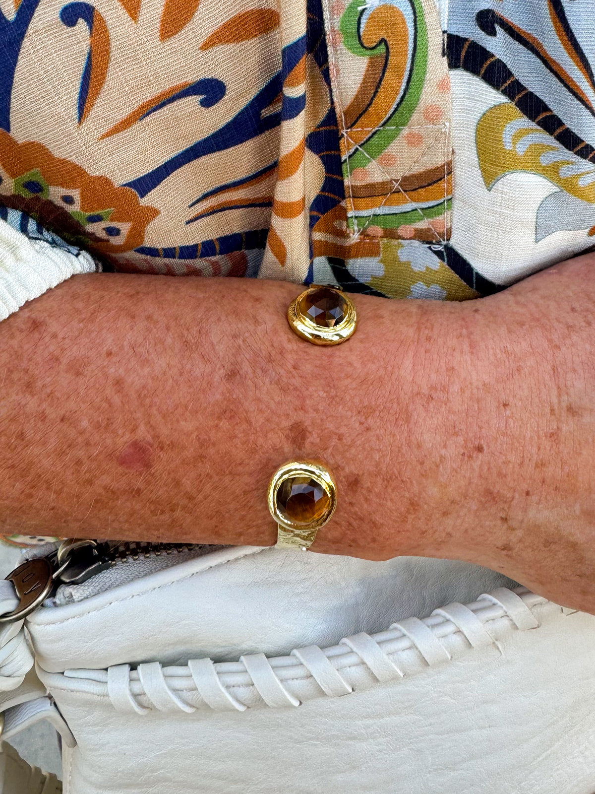 Gold cuff with two round tigers eye stones.