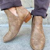 Taupe faux leather ankle booties with side cutouts, back zipper, and block heel.