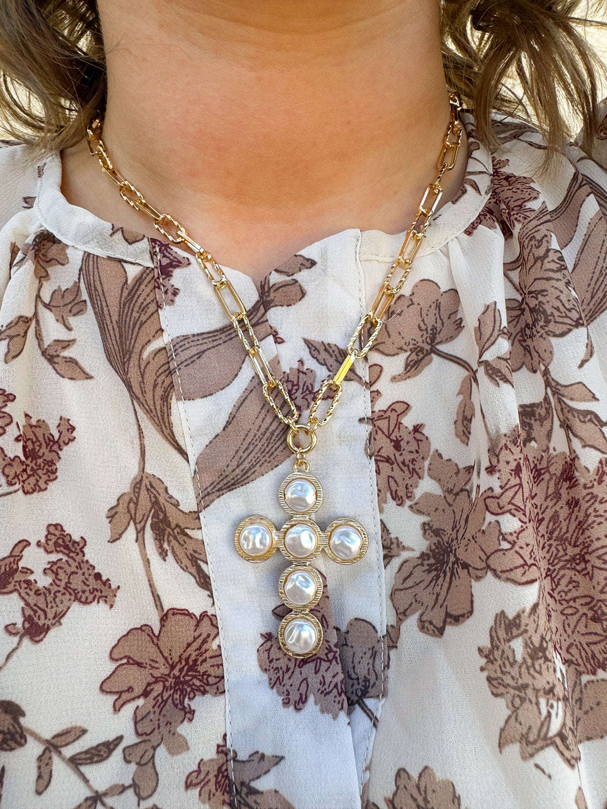 Gold textured oval chain necklace with flat pearl-beaded cross pendant.