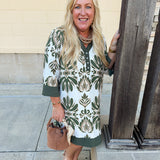 Olive and cream printed mini dress with collared V-neckline, button detailing, ¾ sleeves, and flowy A-line fit.