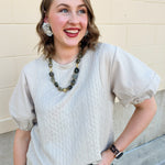 Taupe mixed media top with quilted-style bodice, crew neckline, and faux leather puff short sleeves.