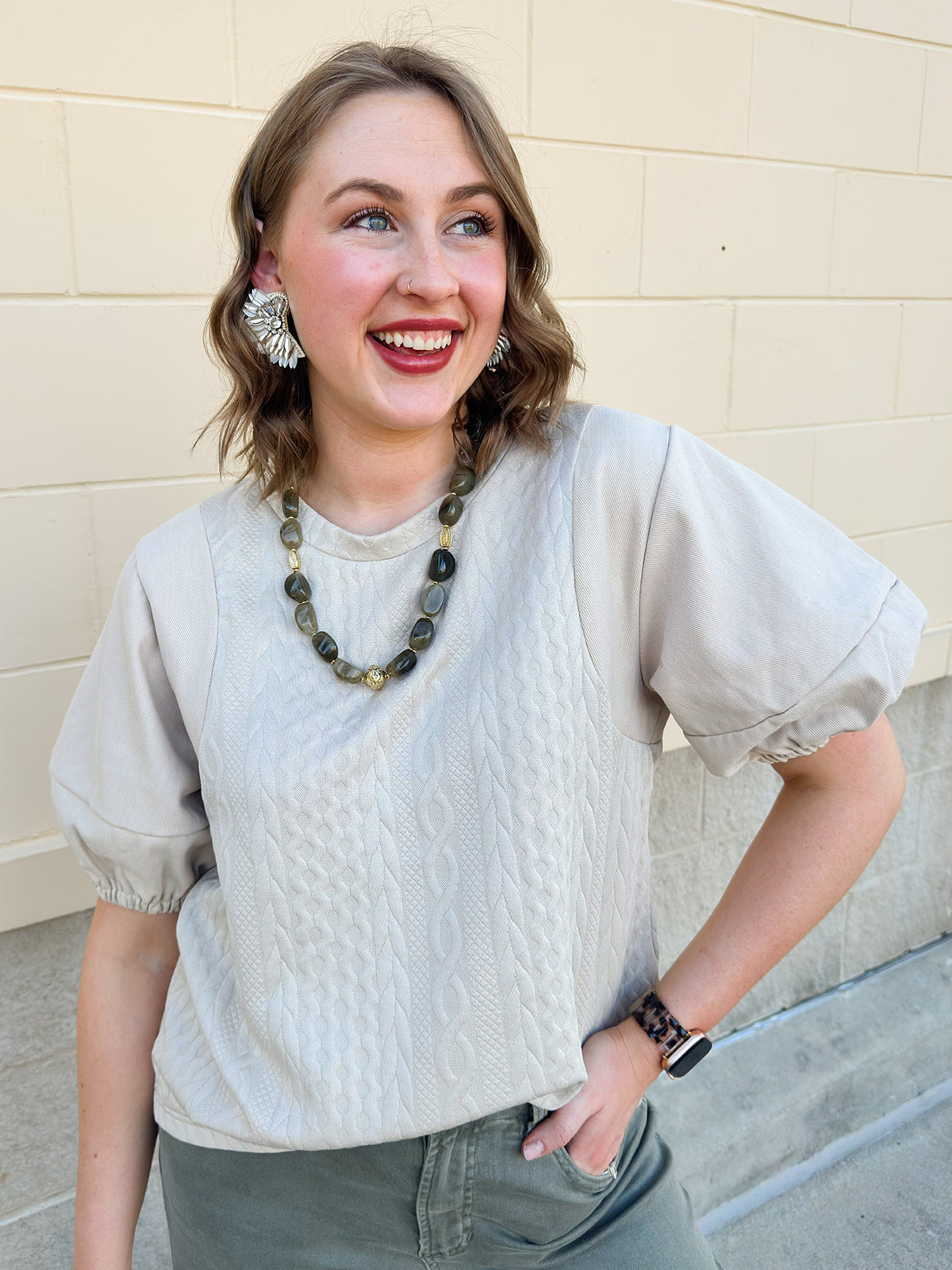 Taupe mixed media top with quilted-style bodice, crew neckline, and faux leather puff short sleeves.