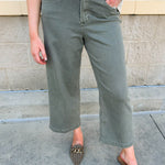 Soft sage green wide leg jeans with high rise and raw cut hem.