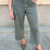 Soft sage green wide leg jeans with high rise and raw cut hem.