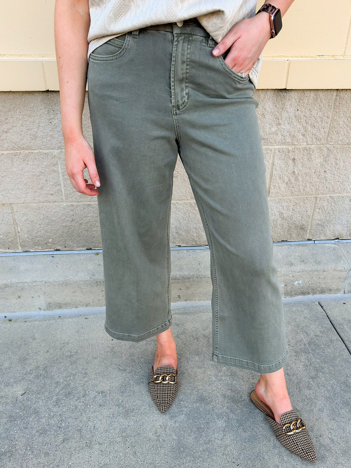 Soft sage green wide leg jeans with high rise and raw cut hem.