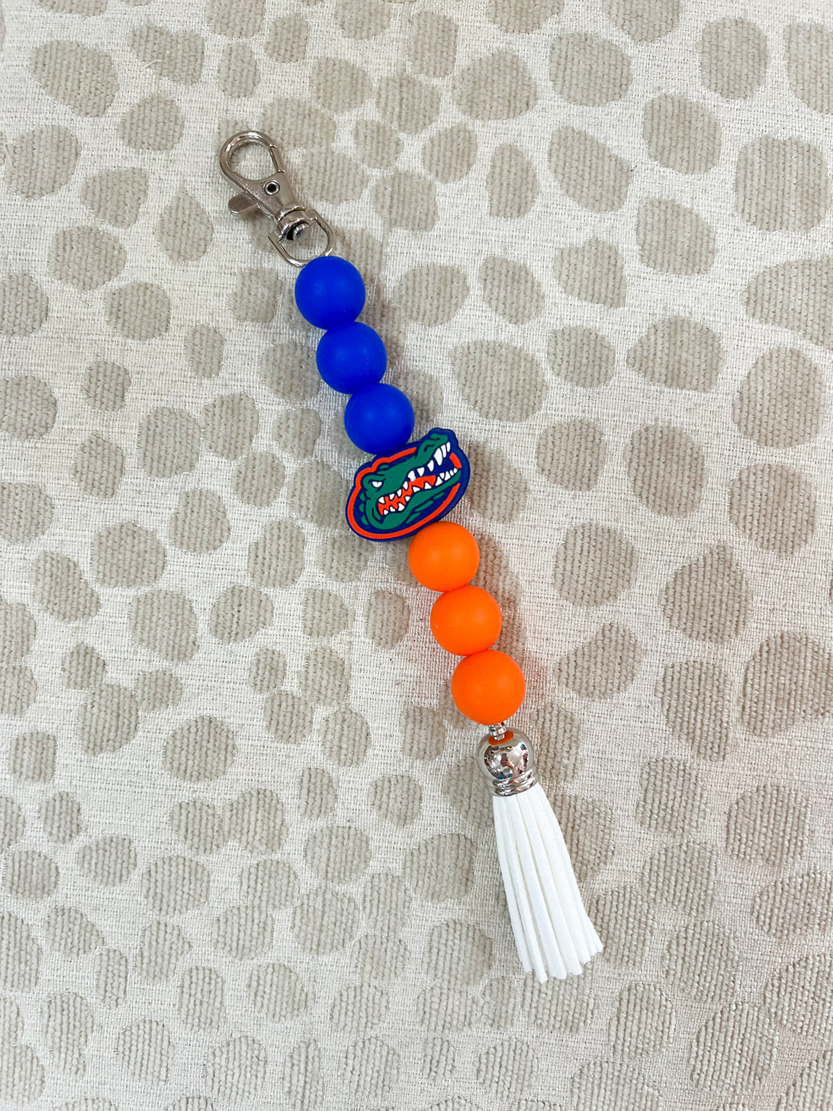 Straight silicone beaded keychain with orange, white, and blue beads and tassel