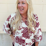 Maroon and cream cherry blossom print blouse with V-neck, 3/4 sleeves, and scalloped hem.