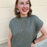 Olive knit sweater with diamond texture, mock neck, and relaxed drop shoulder fit.