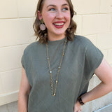 Olive knit sweater with diamond texture, mock neck, and relaxed drop shoulder fit.