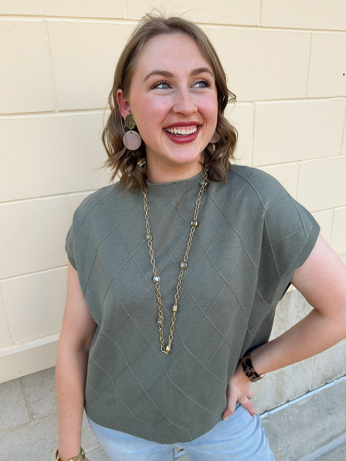 Olive knit sweater with diamond texture, mock neck, and relaxed drop shoulder fit.