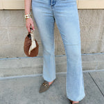 Light wash high-waisted bootcut jeans with tummy control panel displayed folded or hanging against a neutral background