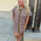 Brown and ivory botanical print mini dress with sage green binding, puff sleeves, ruffled V-neckline, and side pockets.