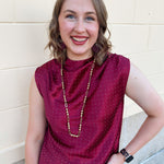 Burgundy sleeveless mock-neck top with rhinestone embellishments across the neckline and bodice.