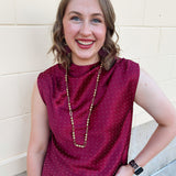 Burgundy sleeveless mock-neck top with rhinestone embellishments across the neckline and bodice.