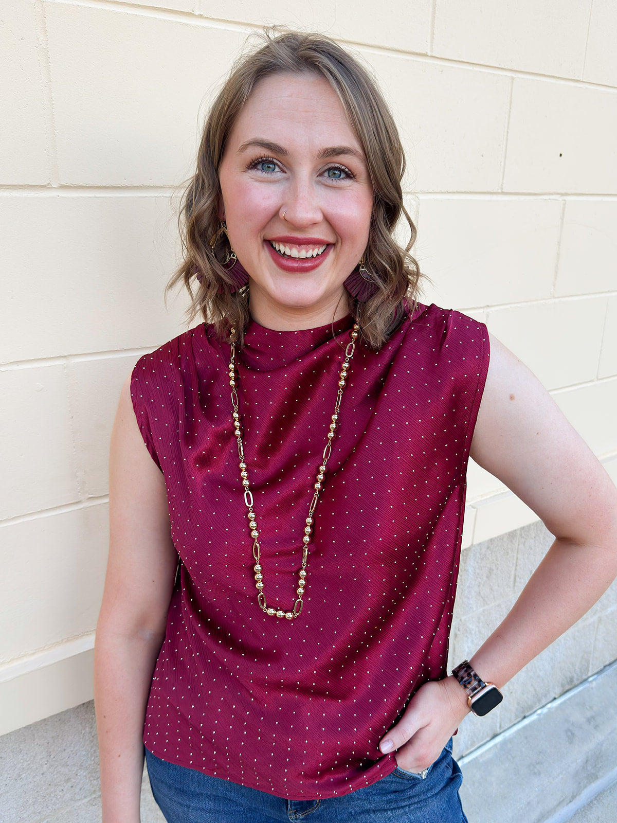 Burgundy sleeveless mock-neck top with rhinestone embellishments across the neckline and bodice.