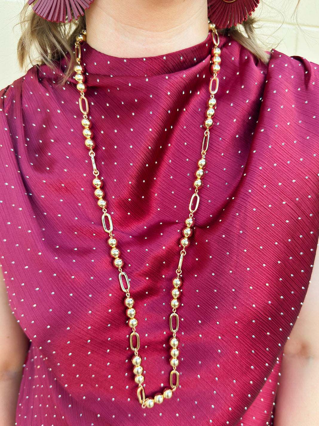 Long gold beaded necklace with alternating round beads and open oval beads, 34" length.