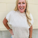 Taupe knit sweater with diamond texture, mock neck, and drop shoulders in a relaxed fit.