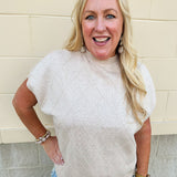 Taupe knit sweater with diamond texture, mock neck, and drop shoulders in a relaxed fit.
