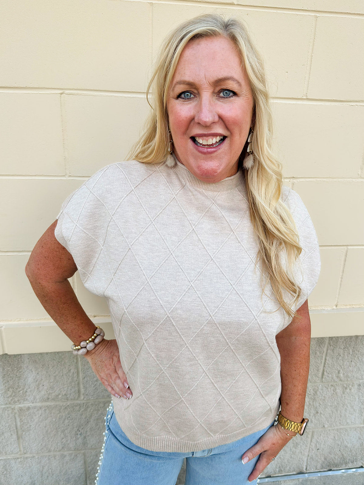 Taupe knit sweater with diamond texture, mock neck, and drop shoulders in a relaxed fit.