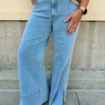  Light wash mid-rise flare jeans with pearl side embellishments and slit hems
