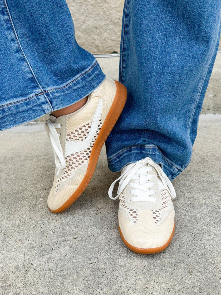 Neutral woven low-top sneakers with muted laces, round toe, and 1-inch heel, styled for casual and fashion-forward everyday looks.