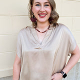 Gold silky blouse with split V-neckline, cuffed short sleeves, and relaxed drape