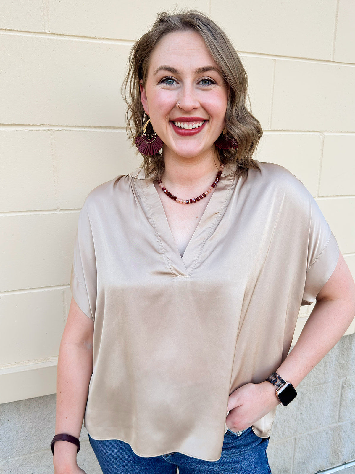 Gold silky blouse with split V-neckline, cuffed short sleeves, and relaxed drape